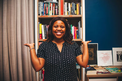 Portrait of smiling young woman standing in library