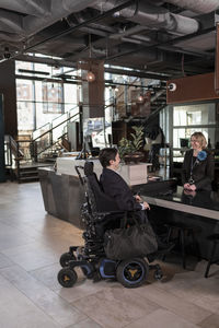 Businessman on wheelchair at hotel reception desk