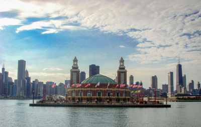 View of buildings at waterfront against cloudy sky