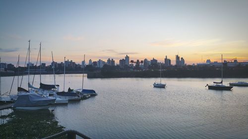 Boats in harbor at sunset