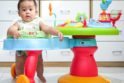 Cute baby girl sitting on table at home