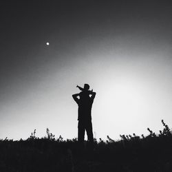 Silhouette of woman standing against sky