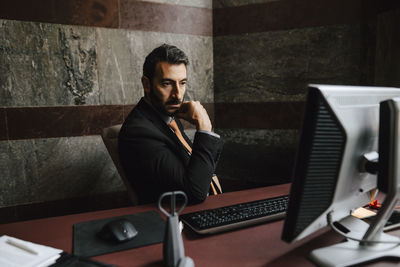 Businessman starting at computer monitor while working in law office