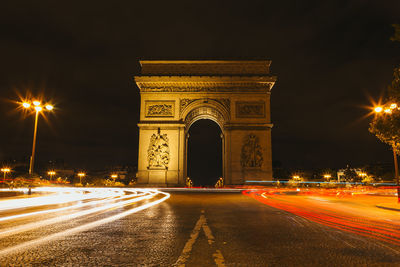 Light trails in city against sky at night