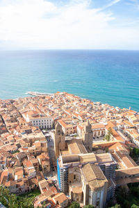 High angle view of townscape by sea against sky