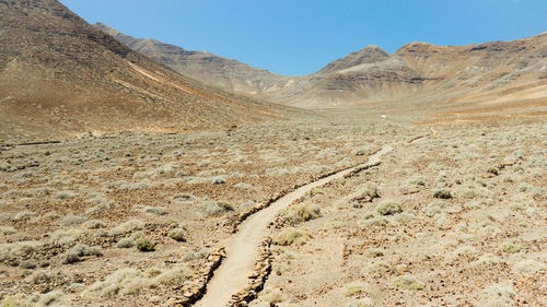 Scenic view of arid landscape against clear sky