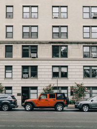 Cars on road by buildings in city