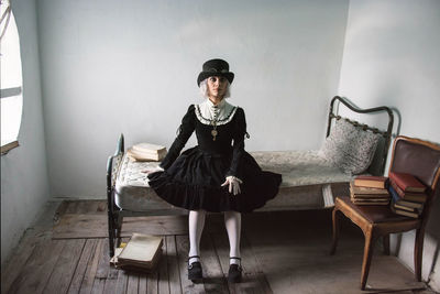 Portrait of woman wearing costume while sitting on bed at home