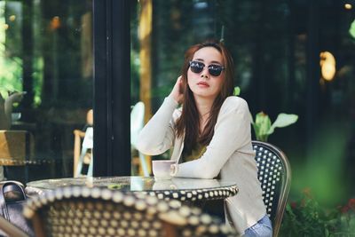 Portrait of young woman sitting on chair