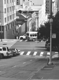 Traffic on road by buildings in city