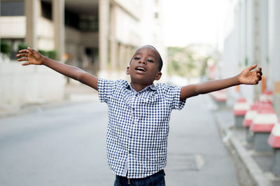 Little boy, arms outstretched and open mouth feels very comfortable and free.