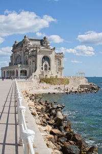 Building by sea against sky