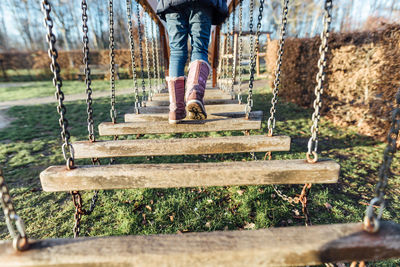 Low section of child walking on play equipment