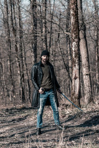 Full length portrait of a man standing in forest