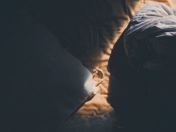 High angle view of pillow and sheet on bed in darkroom