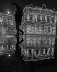 Reflection of man and woman standing in illuminated building