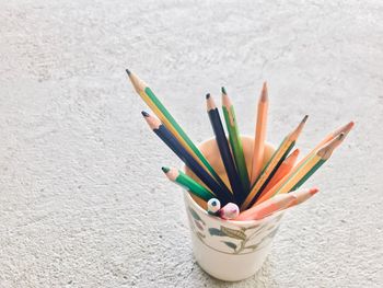 Close-up of multi colored pencils in container on floor