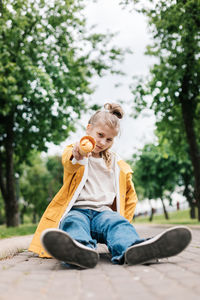 Portrait of a cute blonde teenage girl with ice cream on a walk in the park. child outdoors