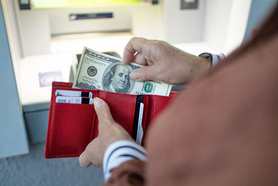 Low section of man holding paper currency