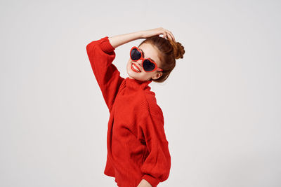 Boy standing against red background