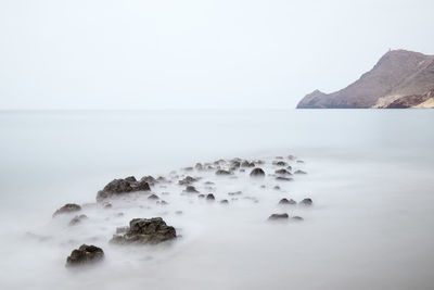 Rocks in sea against sky