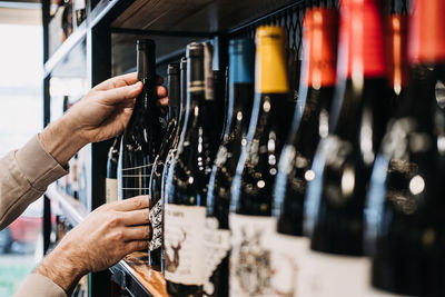 Cropped hand of man holding wine bottles