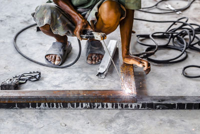 Low section of man welding at workshop