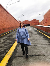 Full length portrait of woman standing on motorcycle