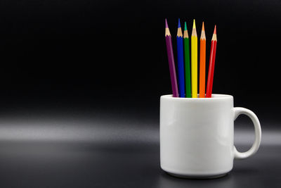 Close-up of colored drinking straws against black background