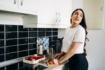 Young woman preparing food at kitchen