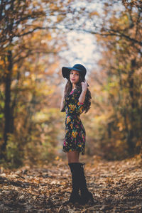 Full length of woman standing in forest