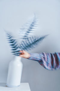 Close-up of woman hand on white wall