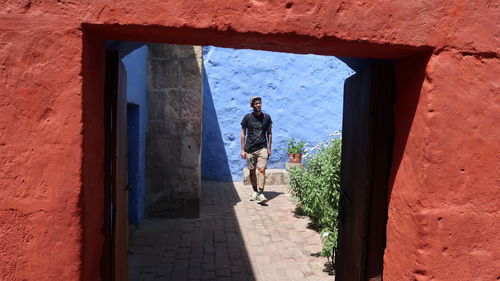 Man standing by wall of building