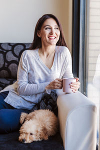 Smiling young woman with coffee cup