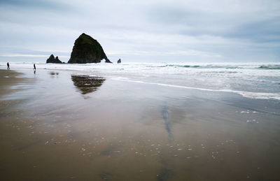 Scenic view of cannon beach against sky