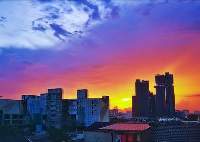 Buildings in city during sunset