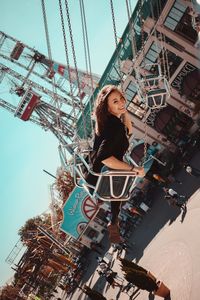 Low angle portrait of carousel against sky