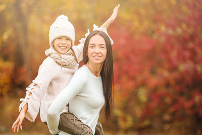 Portrait of smiling young woman in park during autumn