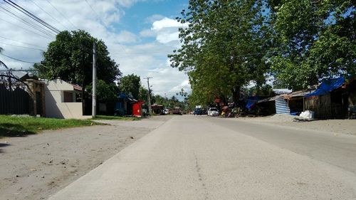 Trees by building against sky