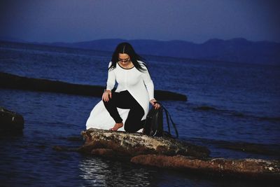 Woman looking at sea against sky