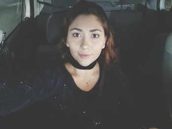 Portrait of smiling young woman sitting in bus