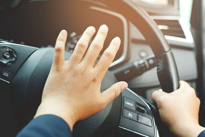 Cropped hands of man using mobile phone in car