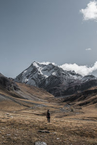 Man walking on mountain against sky