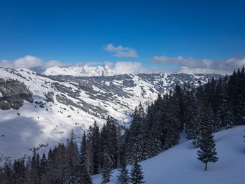 Scenic view of snowcapped mountains against blue sky