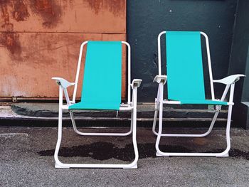 Empty chairs against blue wall