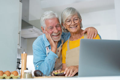 Portrait of senior man using laptop at home