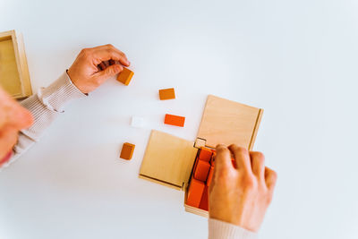 Midsection of woman holding paper against white background