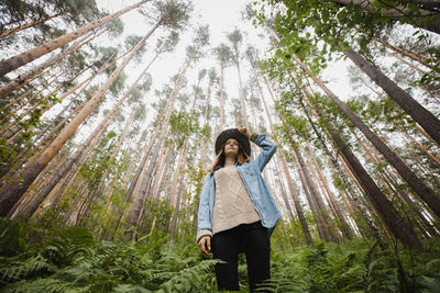 Low angle view of woman standing in forest