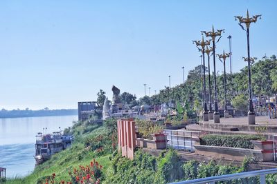 Scenic view of river by buildings against clear sky