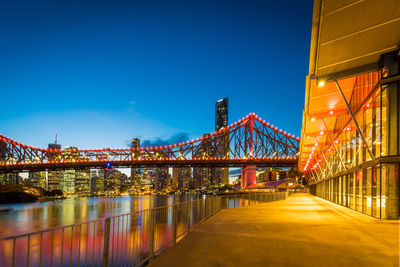 Illuminated bridge against sky at night